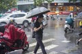 ItÃ¢â¬â¢s raining in the morning, and pedestrians walking through the road pass by the intersection.